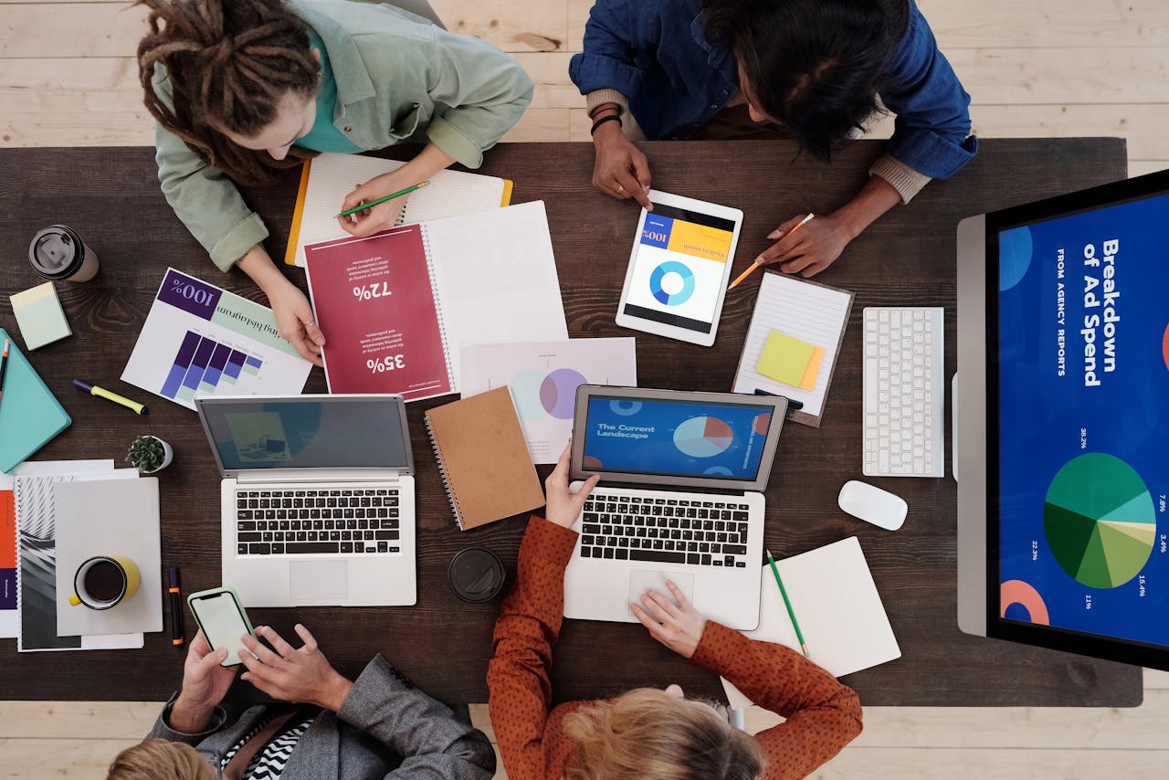 testimonials-img A diverse team collaborating on digital marketing strategies at a desk, using laptops and tablets.
